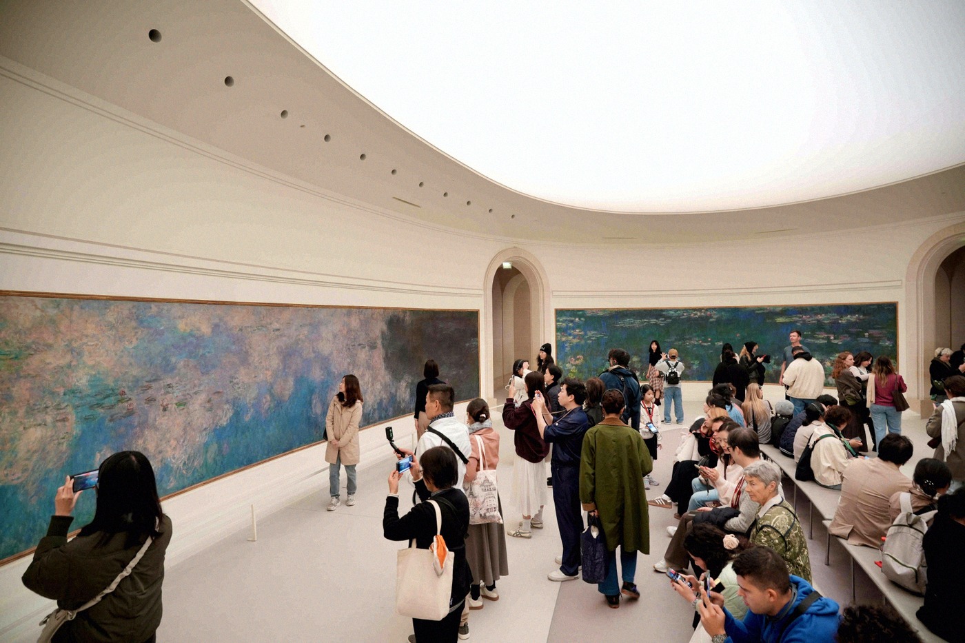 Visitors in the oval room of the Musée de l'Orangerie, in front of Monet's huge water lily panoramas.